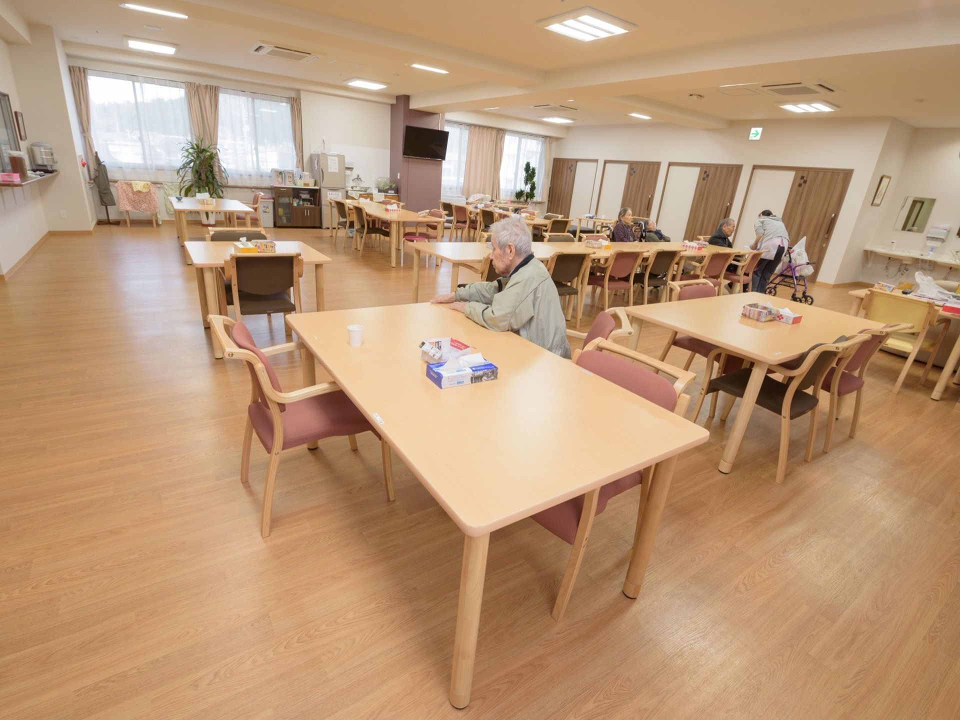 明るく広々とした空間にテーブルと椅子が複数配置されている。車椅子のまま着席できる椅子を置かない席を設けている。