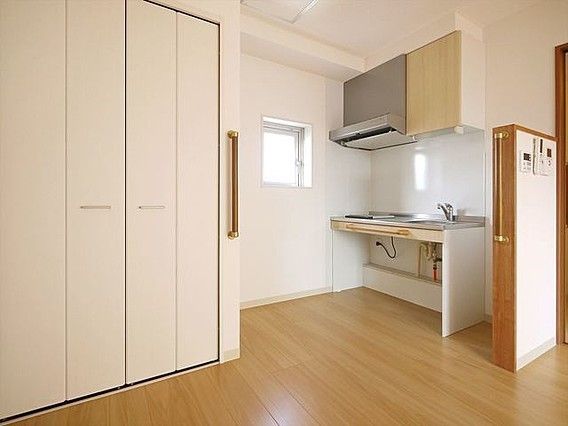 居室にはキッチンと収納が設けられている。座って作業ができる下に空間があるタイプのキッチン。各所に手すりが設けられている。