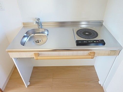 無駄を省いたシンプルでスタイリッシュなシステムキッチン。安全面に考慮してIH調理器が設置されている。