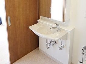 明るく広々とした洗面脱衣所。車椅子をご利用の方も使用しやすい、機能的でスタイリッシュな洗面化粧台が設置されている。