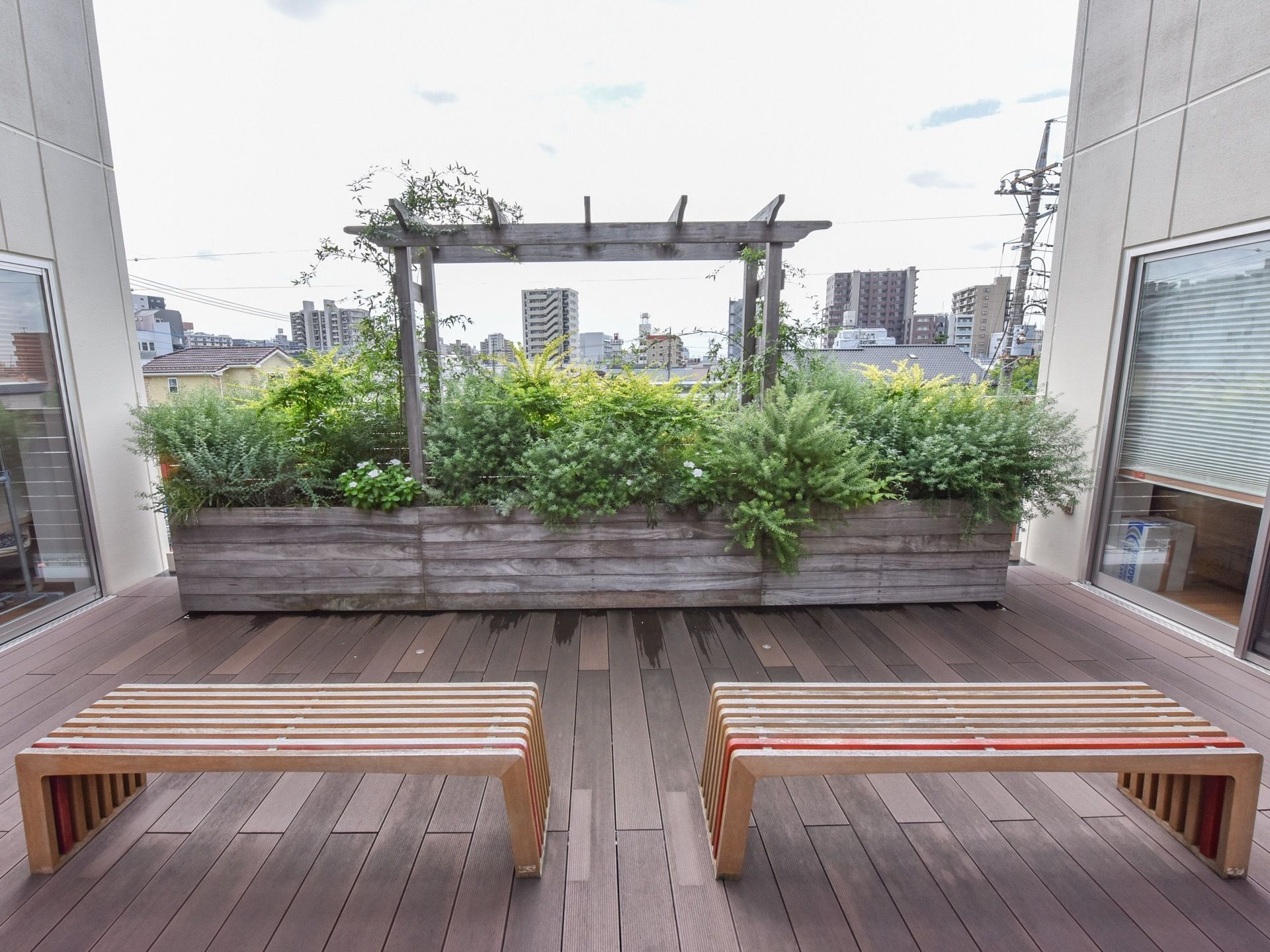 中庭には木製のベンチが2つ並べられている。ベンチの目の前には石で作られた大きな花壇が設置されている。