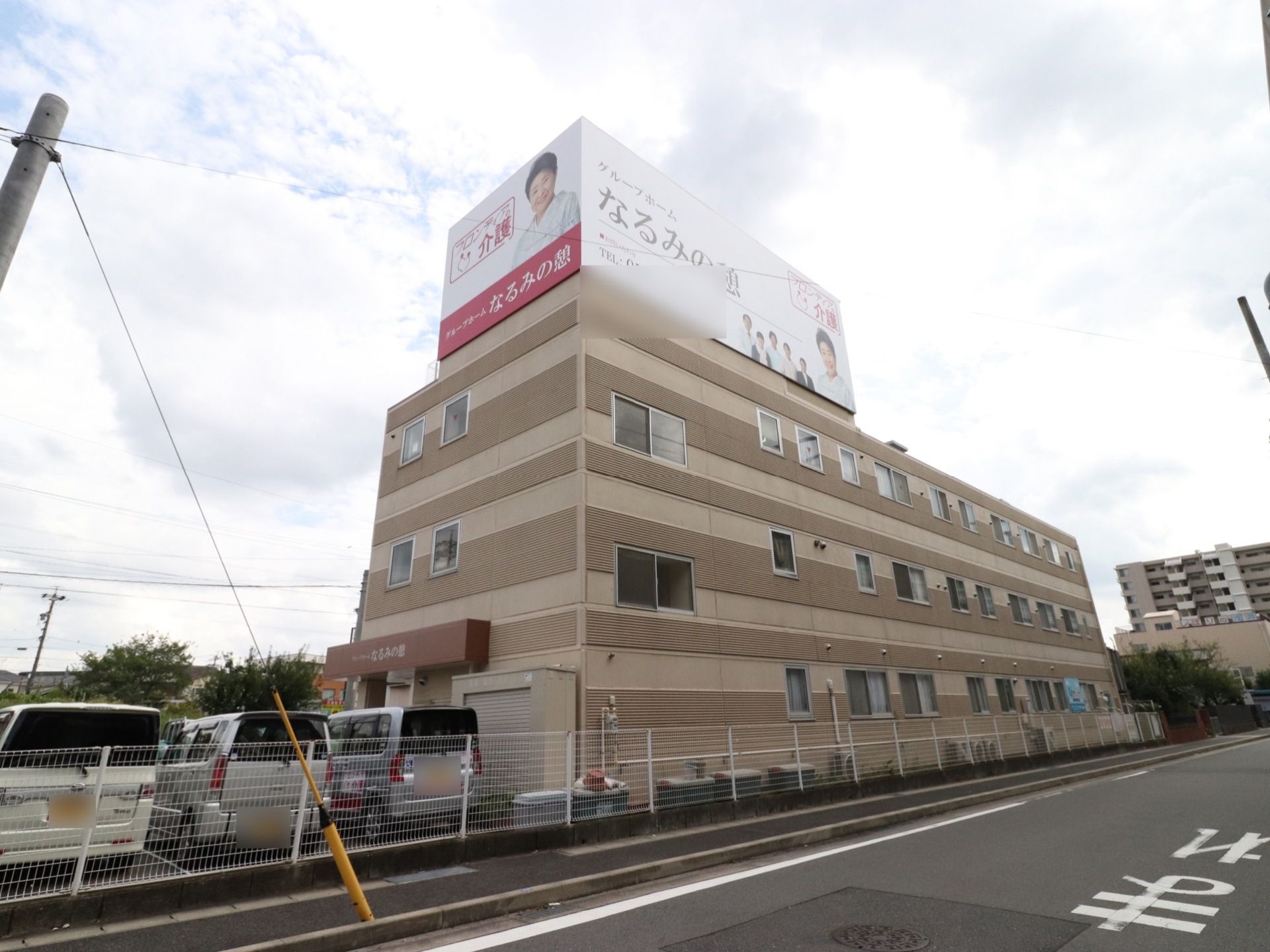 黄土色系のツートンカラーの外観の３階建ての建物である。敷地と外部を白色の格子の柵で仕切っている。建物の一番上に大きな看板を掲げている。