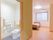 居室入口付近の幅の広い引き戸を開けるとトイレが設置されている。壁には手すりが縦や横向きに設置されている。