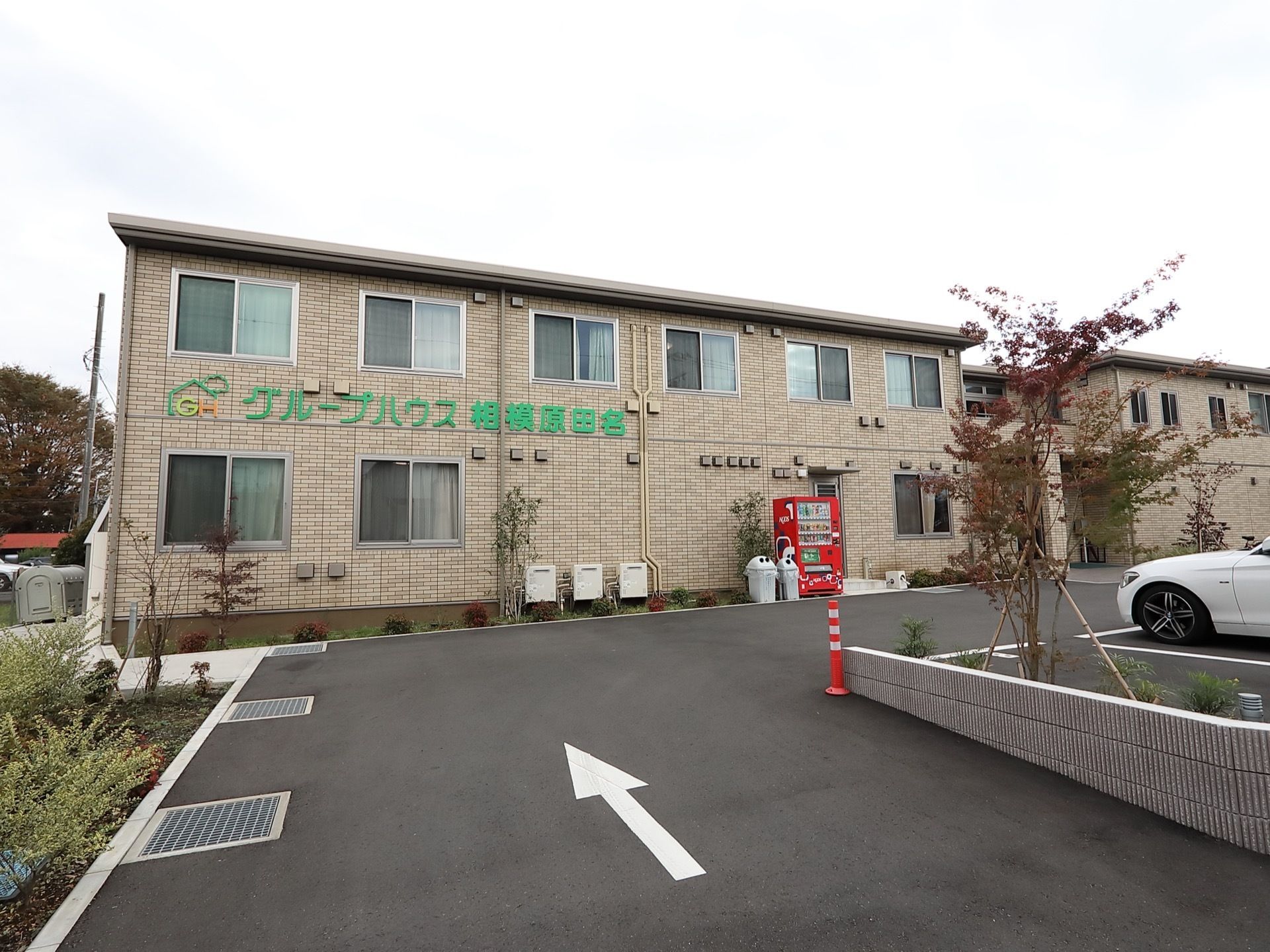 レンガ調の壁の、横に長い２階建て施設の外観。各部屋に大きな窓が備わっているのが見られる。広い駐車場が完備されている。