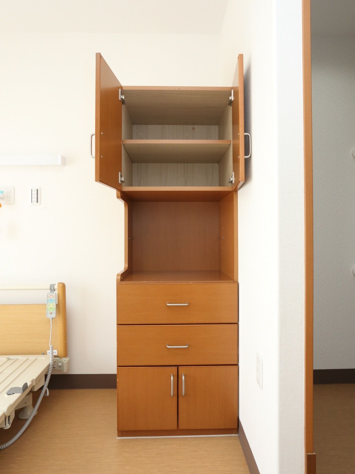 ベッドの傍には収納棚が備え付けられている。本や小物などの収納から洋服までを収納でき、部屋をきれいに使用することができる。