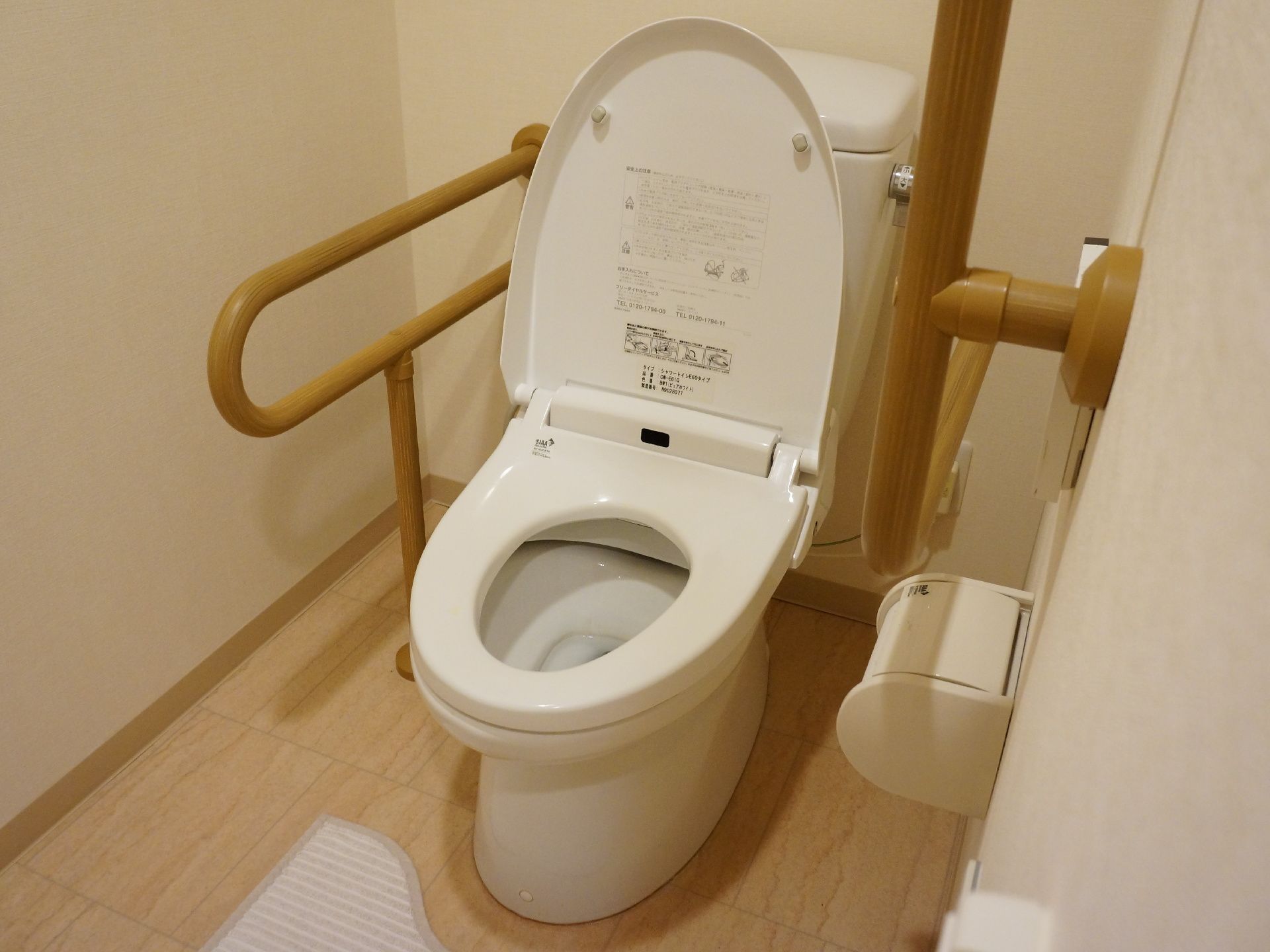 トイレは、タンクサイドに水洗するレバーがあるタイプである。便座シートの右にも左にも手すりが設置されている。