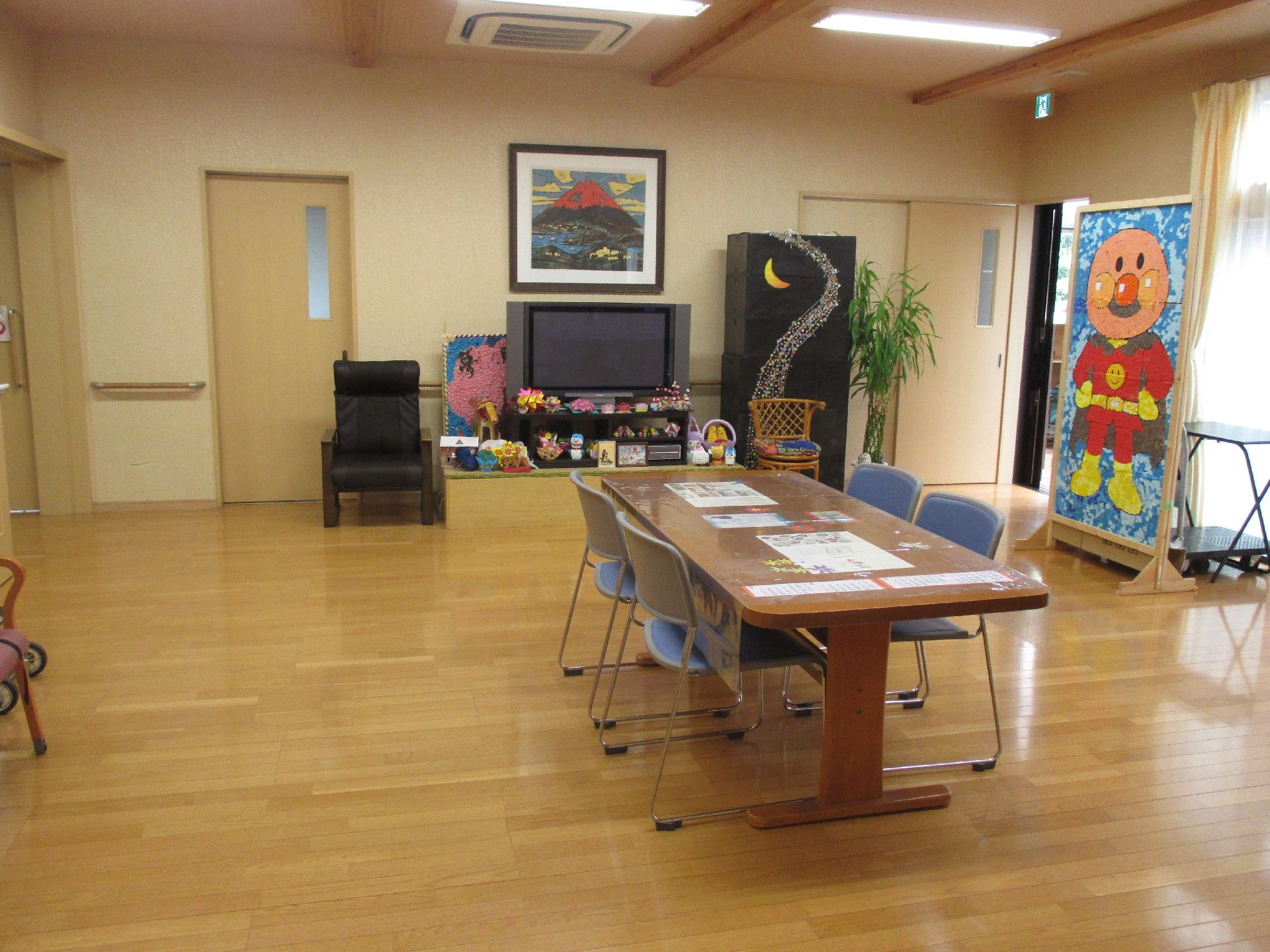 広いテーブルと椅子４脚置かれている。入居者様同士で椅子に座り談笑を楽しむなど、自由にくつろぐことができる。