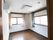 角部屋に位置している明るい雰囲気の居室。床はフローリング敷になっており、白い壁にエアコンが取り付けられている。