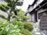 建物に沿って綺麗に刈り込まれている日本庭園がある。庭園の敷居には和風の塀がある。地面は玉砂利と飛び石が置かれている。