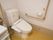 トイレには白い温水洗浄便座が設置されている。壁にはL字型の手すりや、ナースコールなどが取りつけられている。