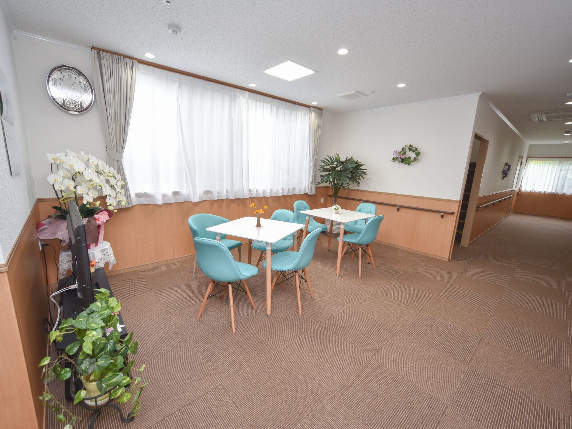 4人掛けのテーブルがあり、観葉植物を多く飾った談話スペース