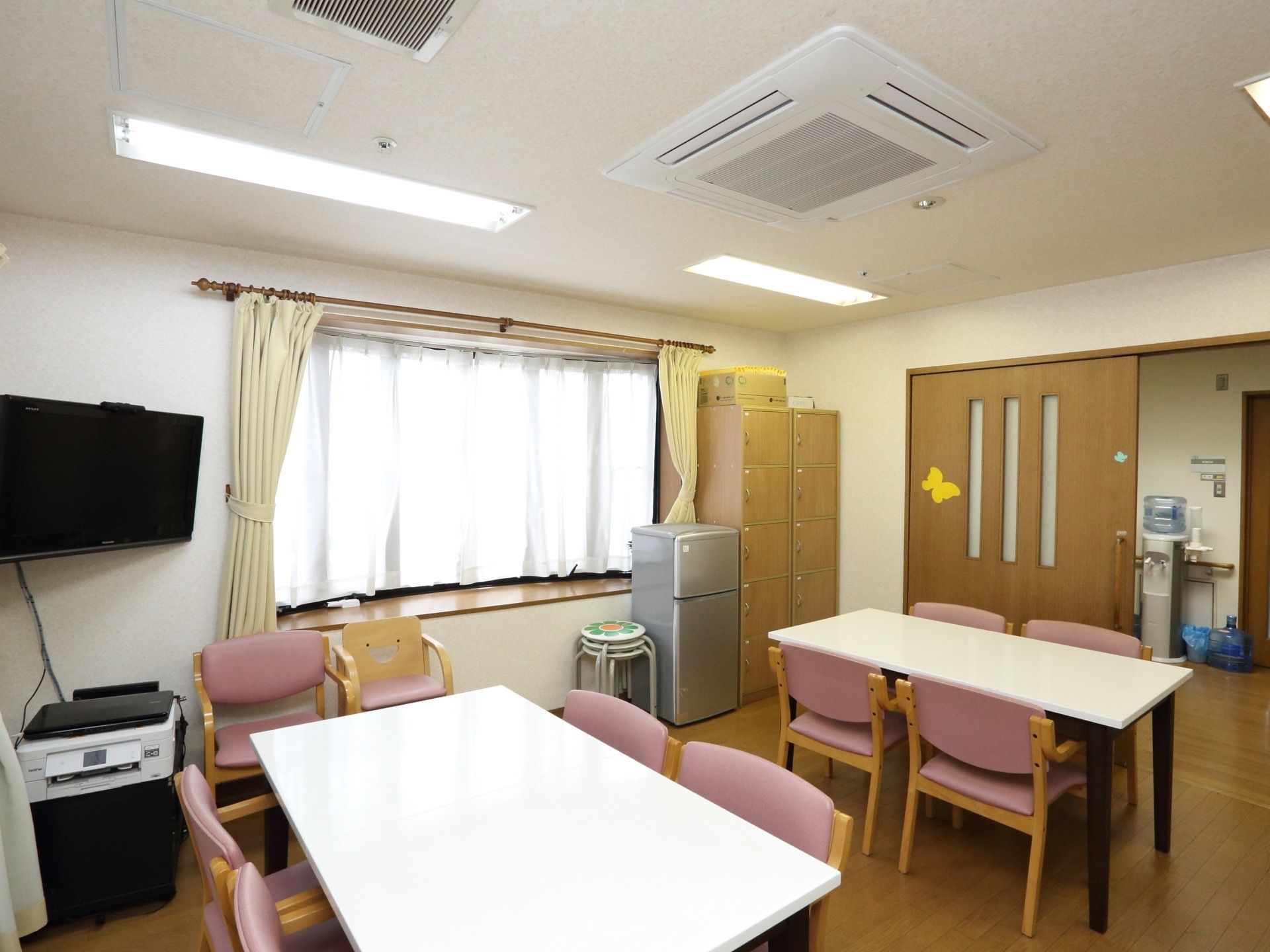 多目的室には、４人がけのテーブルセットがある。椅子のシートはピンク色で、テレビが壁際のコーナーに設置してある。
