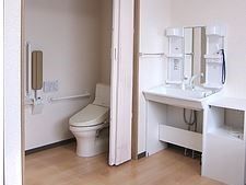 トイレのドアはアコーディオンカーテンを採用しており、居室内にある。手すりを設置しており、安全に利用することができる。