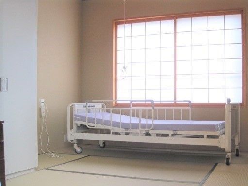 居室の窓からは温かな光が差し込んでいる。ナースコールを設置しているので、安心しておくつろぎいただける。