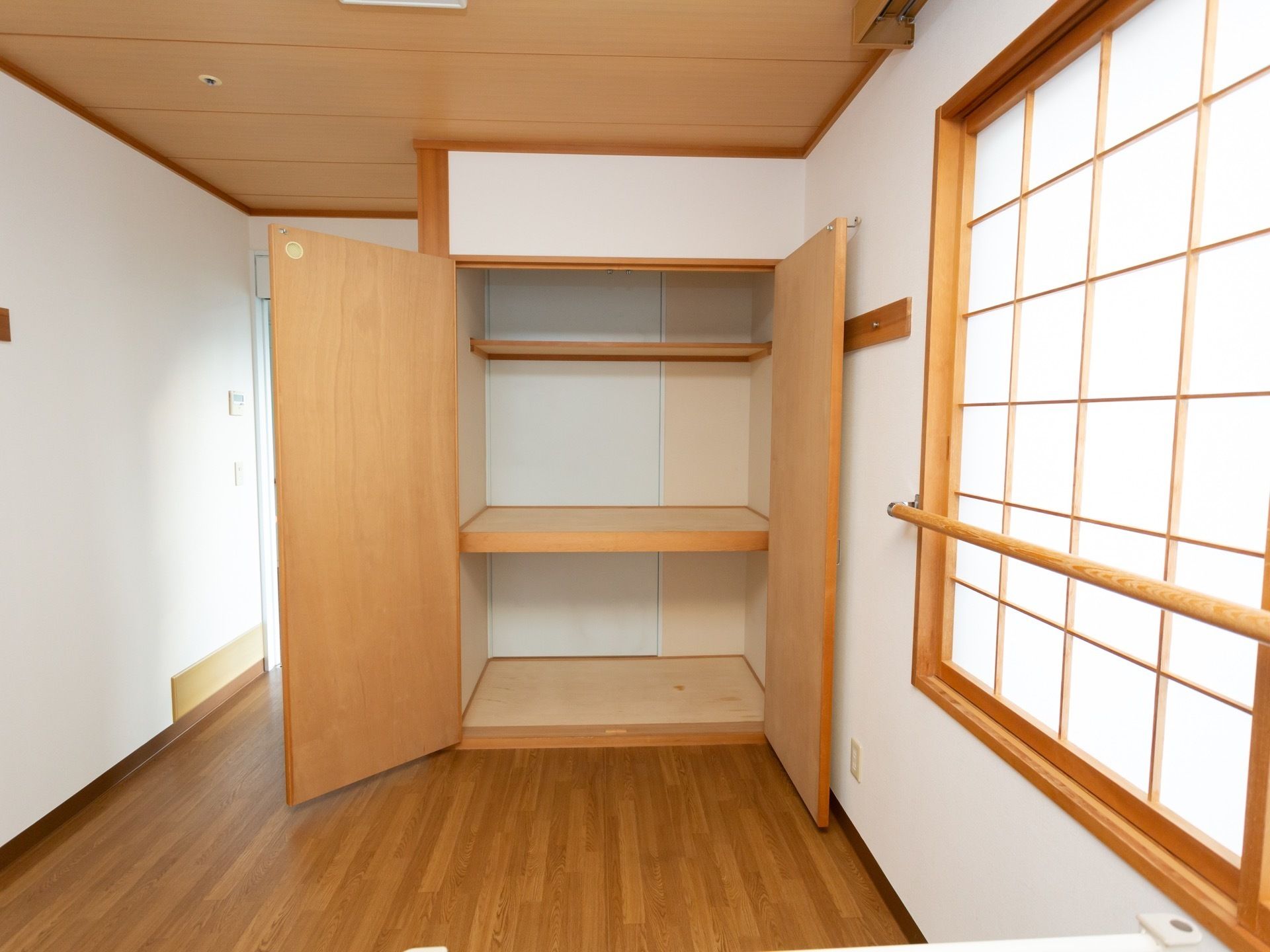 居室には観音開きの扉の収納スペースが備え付けられている。中は押し入れのように中板によって上下２段に分けられ、さらに上部には枕棚がある。