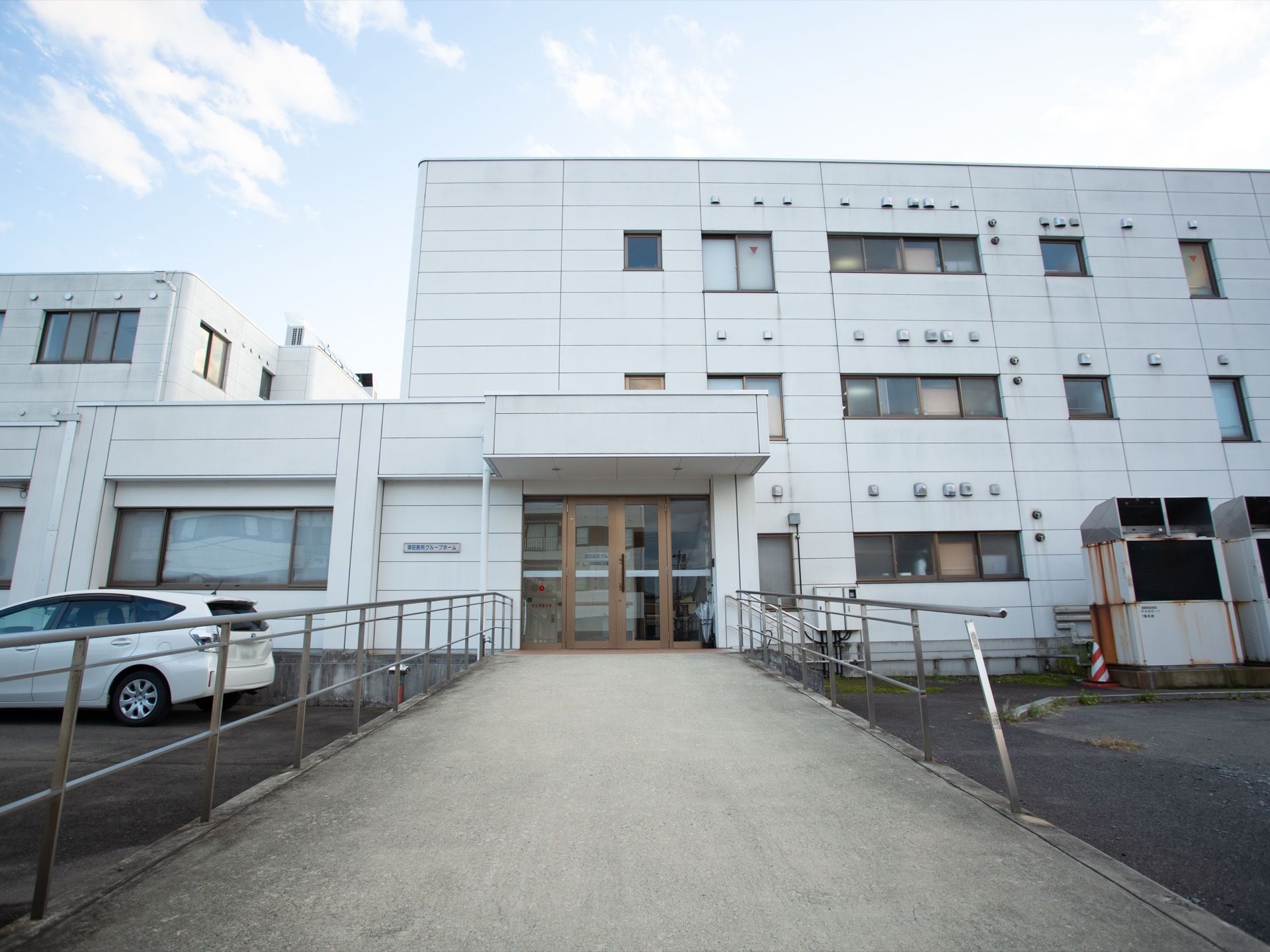 施設の建物は３階建てで、白色を基調とした外観である。玄関のドアの前に通じるスロープは通路幅が広く手すりが備わっている。