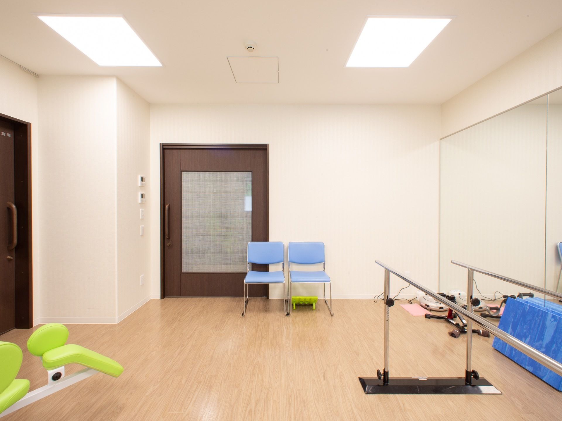 機能訓練室内には、歩行訓練や柔軟性を高めるためのさまざまなトレーニング器具が完備されている。椅子が２脚置かれている。