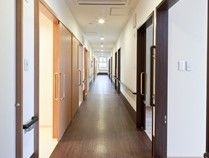 障害物のない真っすぐの通路で、壁に手すりを完備。天井には丸形の照明が複数備え付けられ、夜間時も安全に通行できる。