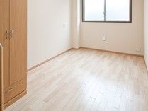 明るい床色が、あたたかい雰囲気をつくりだしている。木製のクローゼットが設置されており、服や日用品などが収納できる。