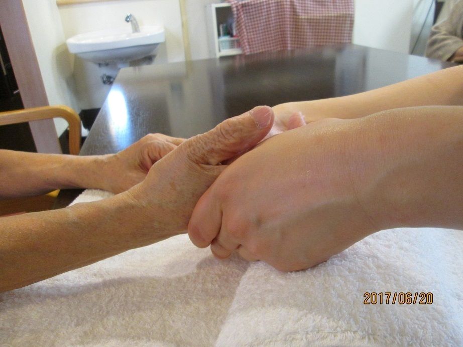 入居者様の手に触れて、健康状態を確認しているスタッフ
