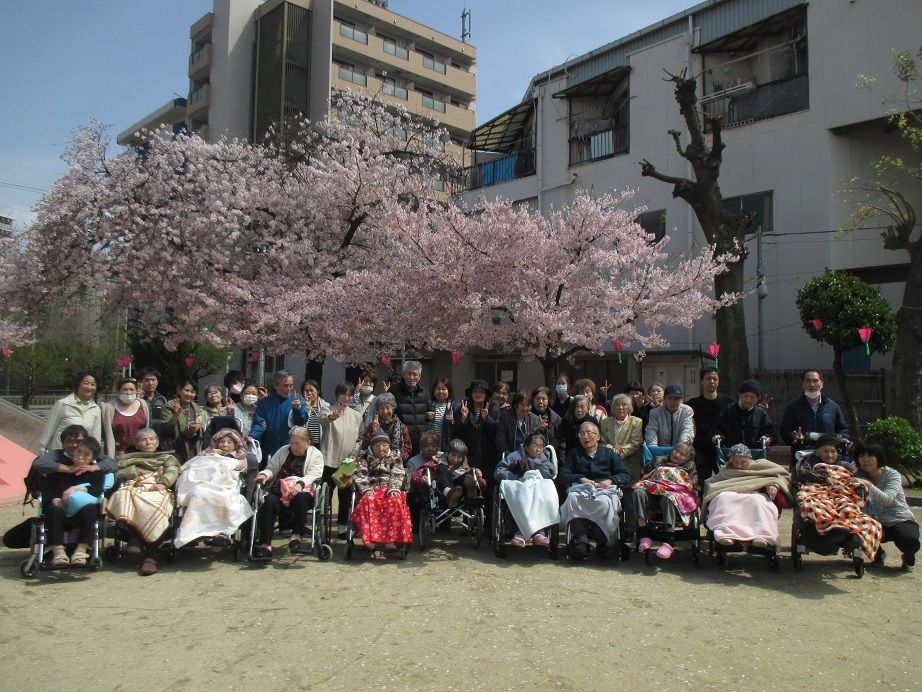 施設近くの広い公園にお花見に来て、笑顔を見せる入居者様