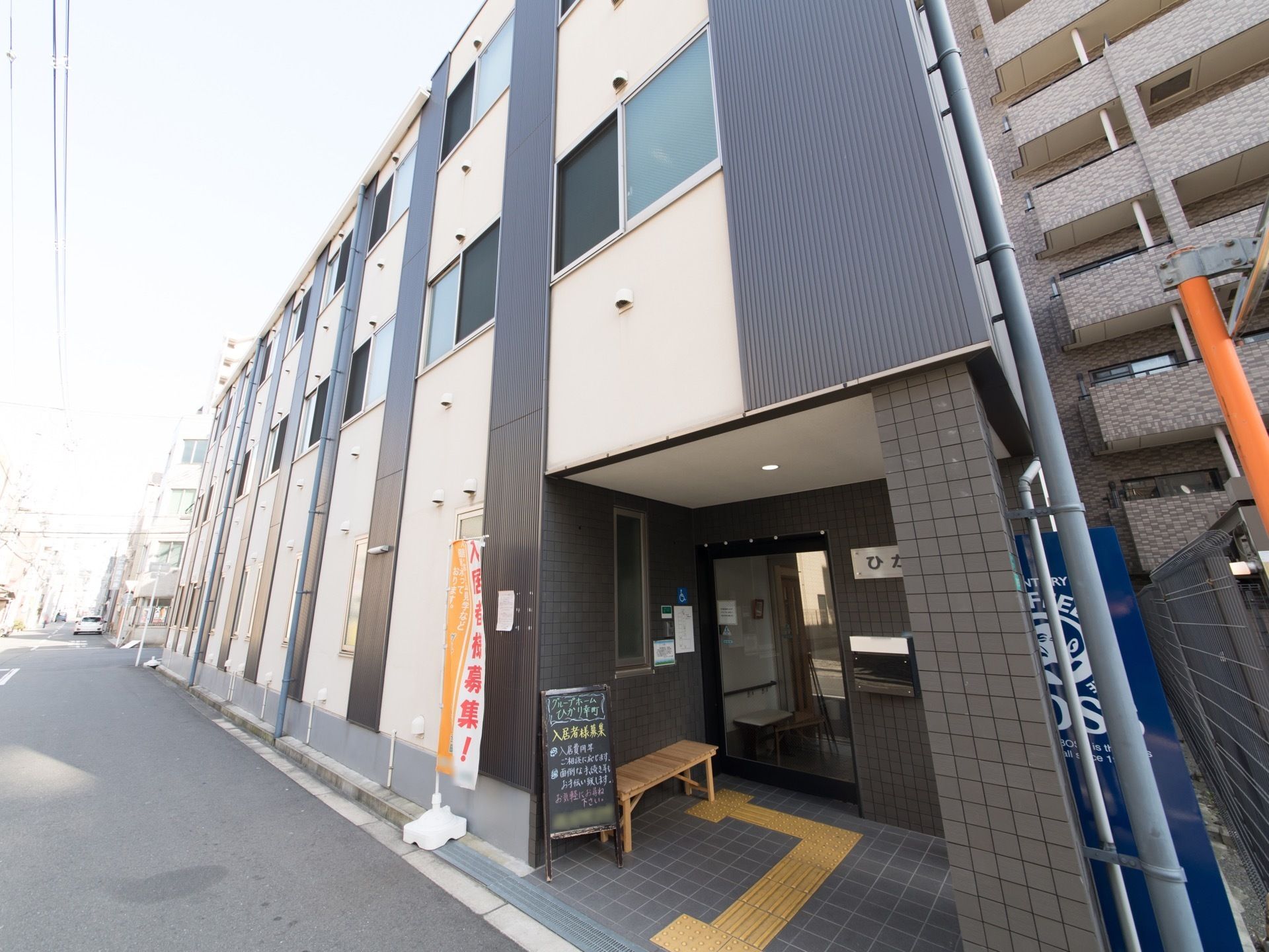 出入口の自動ドアは透明なガラス製になっており、中の様子が見えるようになっている。道路脇には、のぼりや看板が置いてある。