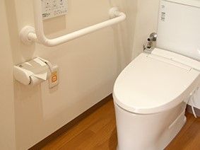 お尻を洗浄する機能がついたトイレになっている。手すりやナースコールがあり、安全にトイレを利用することができる。