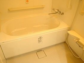 ゆっくりと入れる広めの浴槽。動作に合わせた手すりが壁に設置され、緊急時に備えた呼出用のボタンがつけられている。