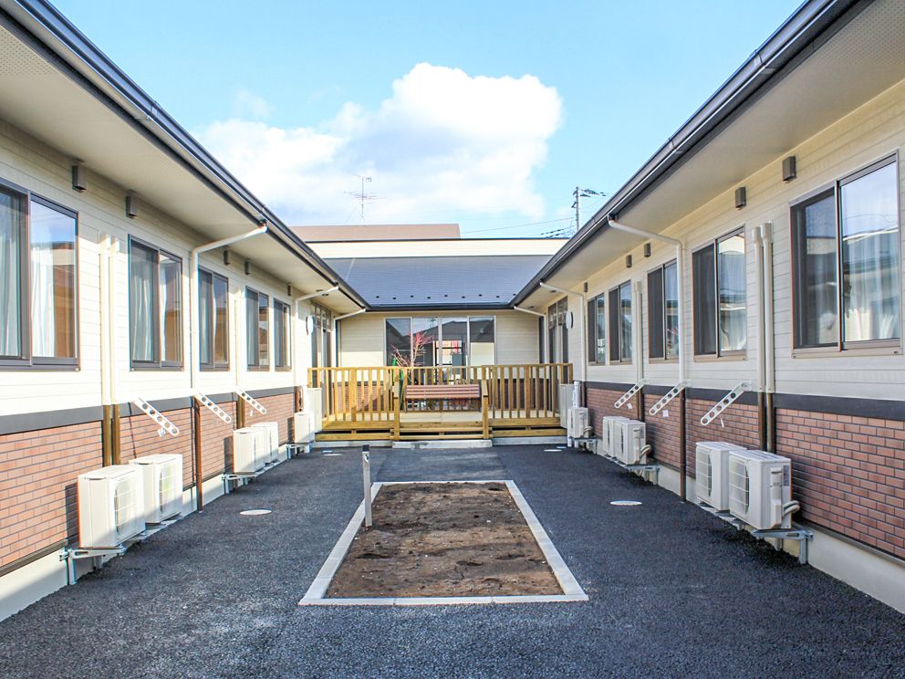 コの字型の建物の間に菜園スペースが設けられている。土に触れる喜びを感じながら入居者様同士の交流も深められる。