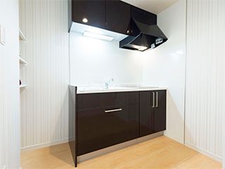 収納棚も豊富についている、換気扇付きの黒いキッチン