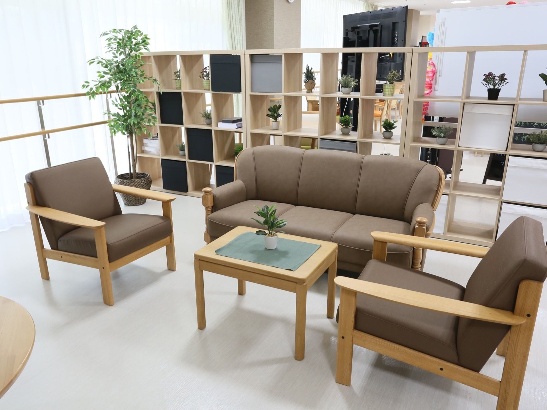 ゆったりとしたソファーは、ブラウン系の落ち着いたデザインである。後方には収納ボックスがあり、さまざまな物が置いてある。