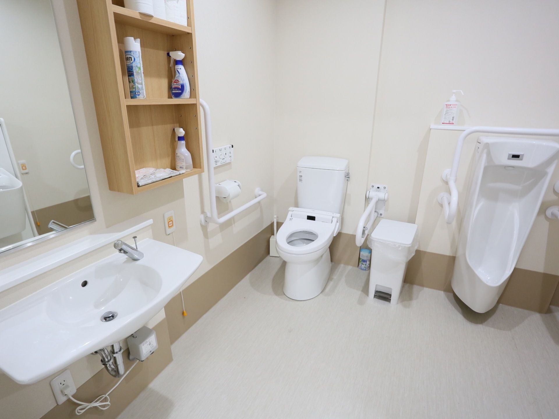 男女共用のトイレには、鏡付きの洗面台も設置されている。壁には収納棚があり、消臭スプレーやトイレ用洗剤が並んでいる。