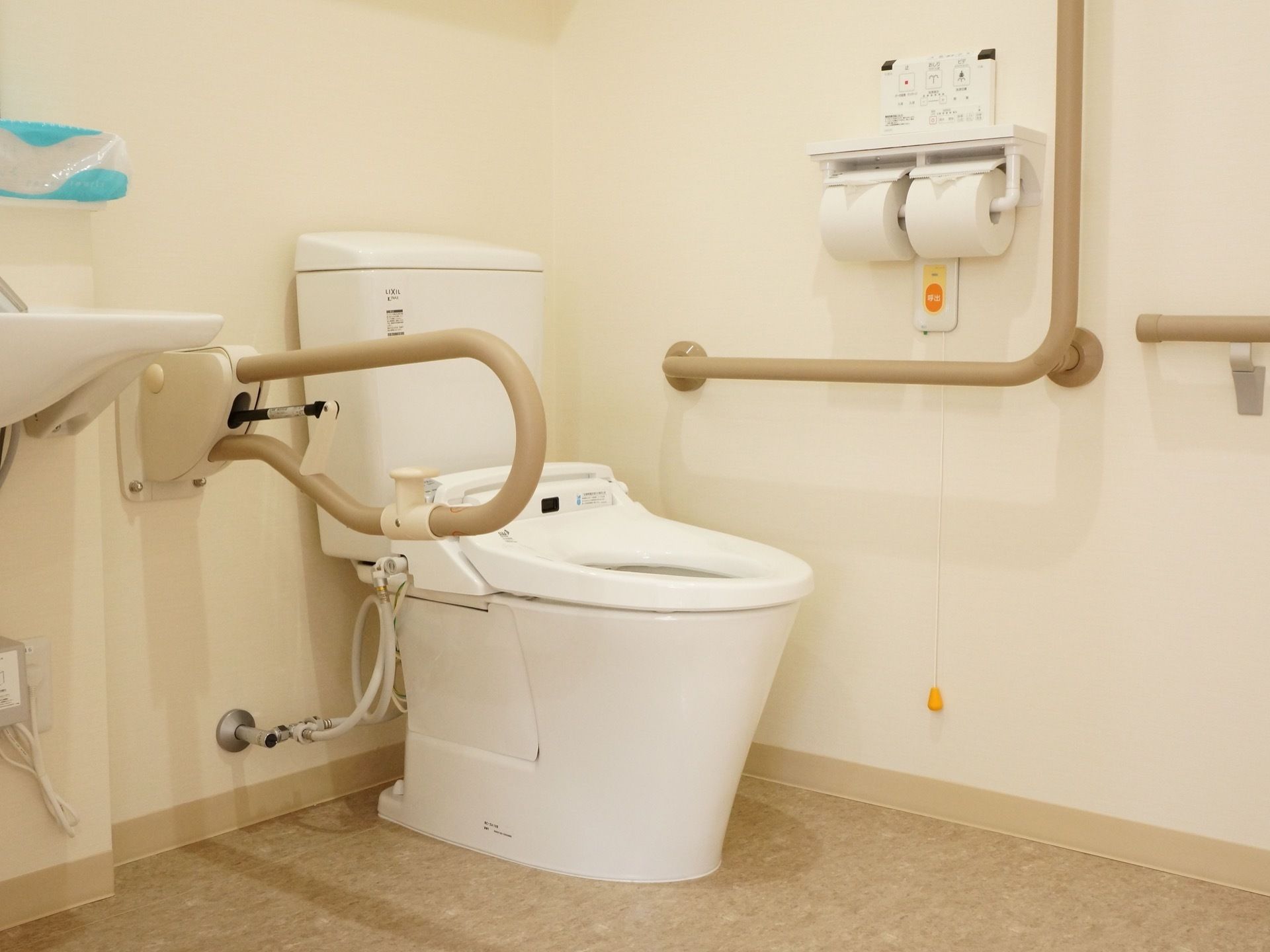 トイレの壁には呼出用の押しボタンに引き手が付けられており、入居者様は緊急の際には介護スタッフを呼ぶことができる。