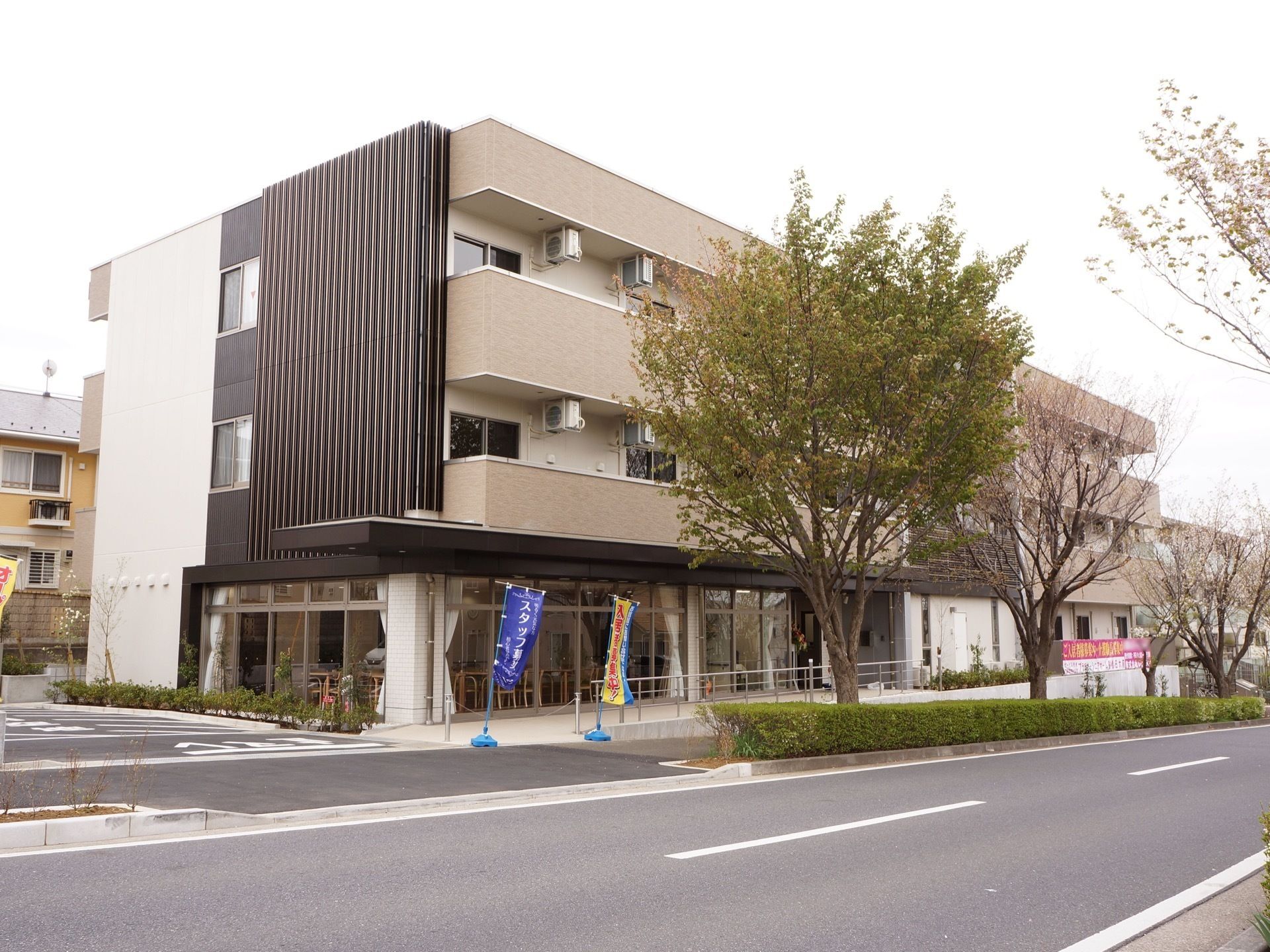 施設の建物は緩やかな坂道に面した場所にあり、手前側は駐車場の出入口で道路からスムーズにアクセスすることができる。