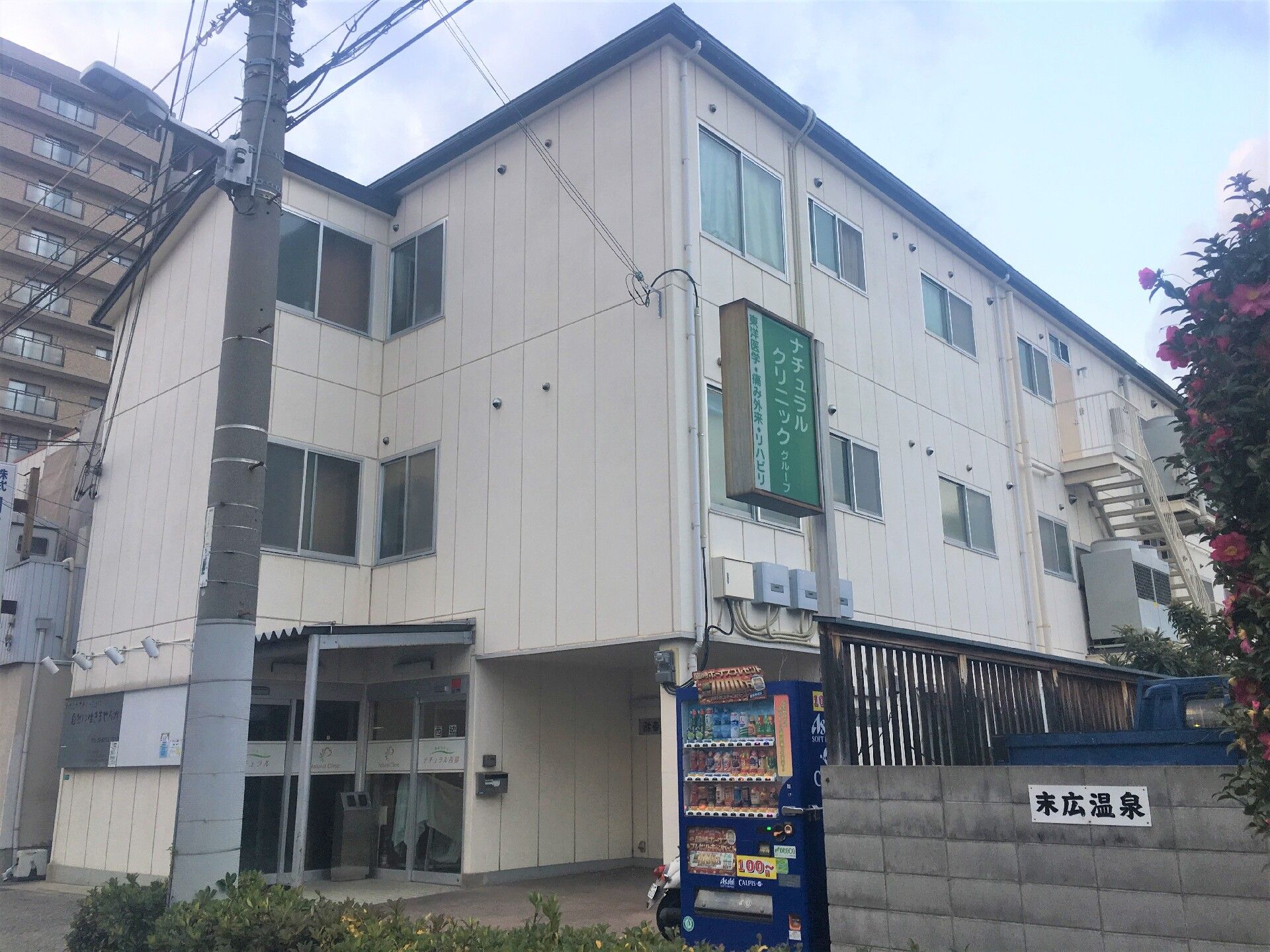 温泉やクリニックの看板が目印となっている、施設の外観