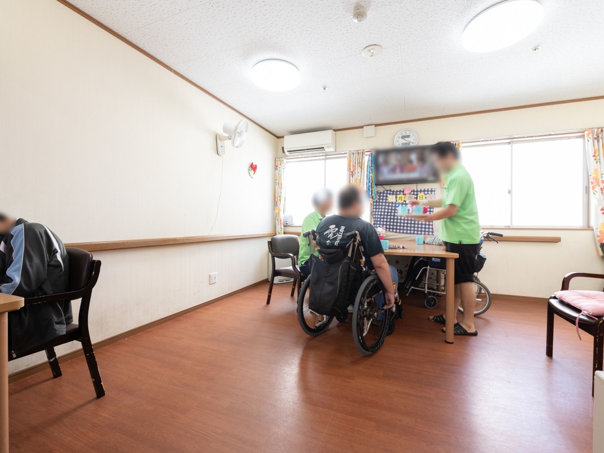 テレビを見ているところに、スタッフから飲み物を提供される入居者様