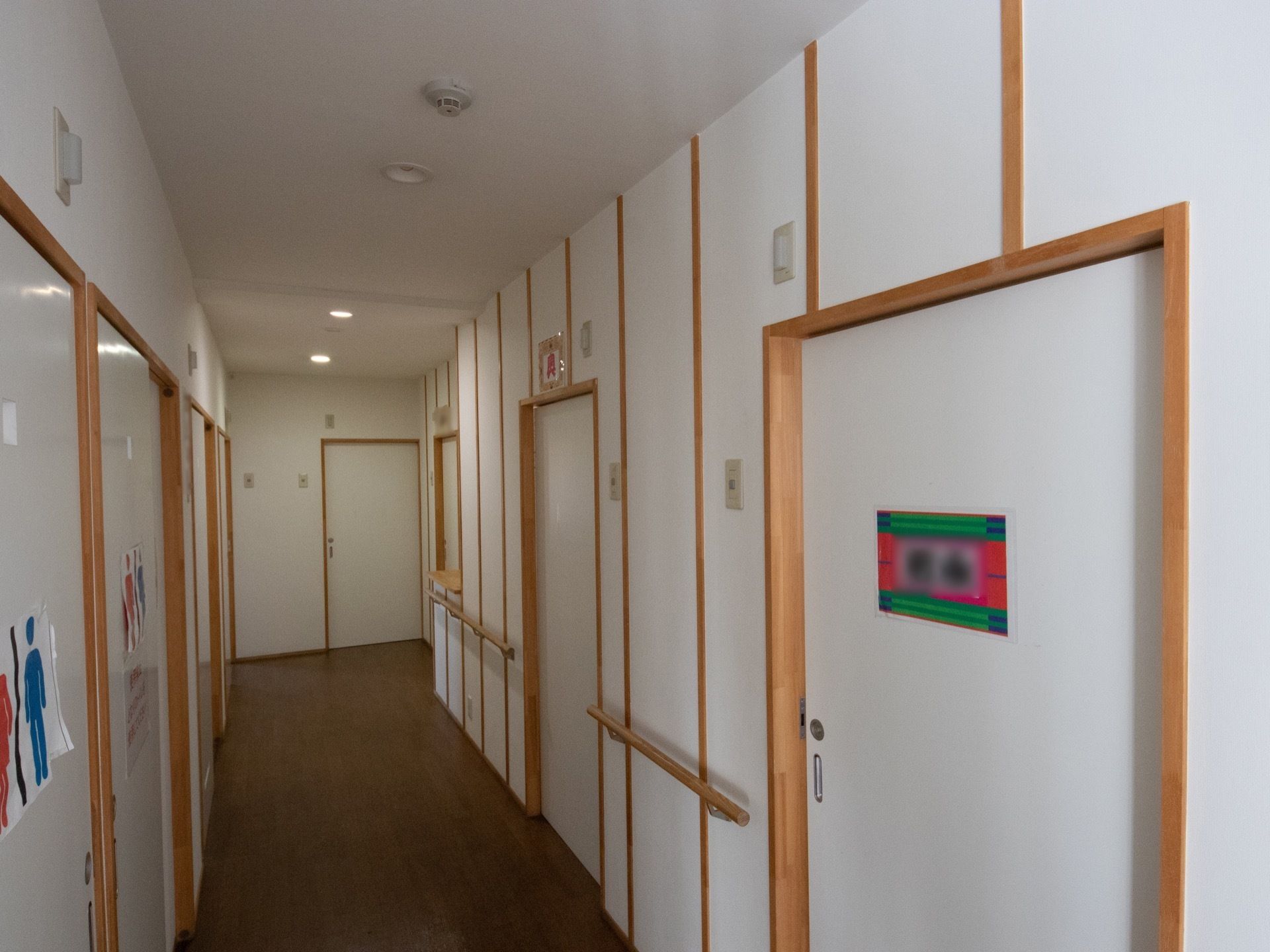 壁は真っ白く明るい雰囲気になっている。居室の扉は幅の広い引き戸式を採用している。壁には木製の手すりが設置されている。