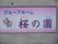 施設名が大きく書かれた看板がある。ピンクを基調としたデザインになっており、おしゃれな雰囲気を感じさせる。