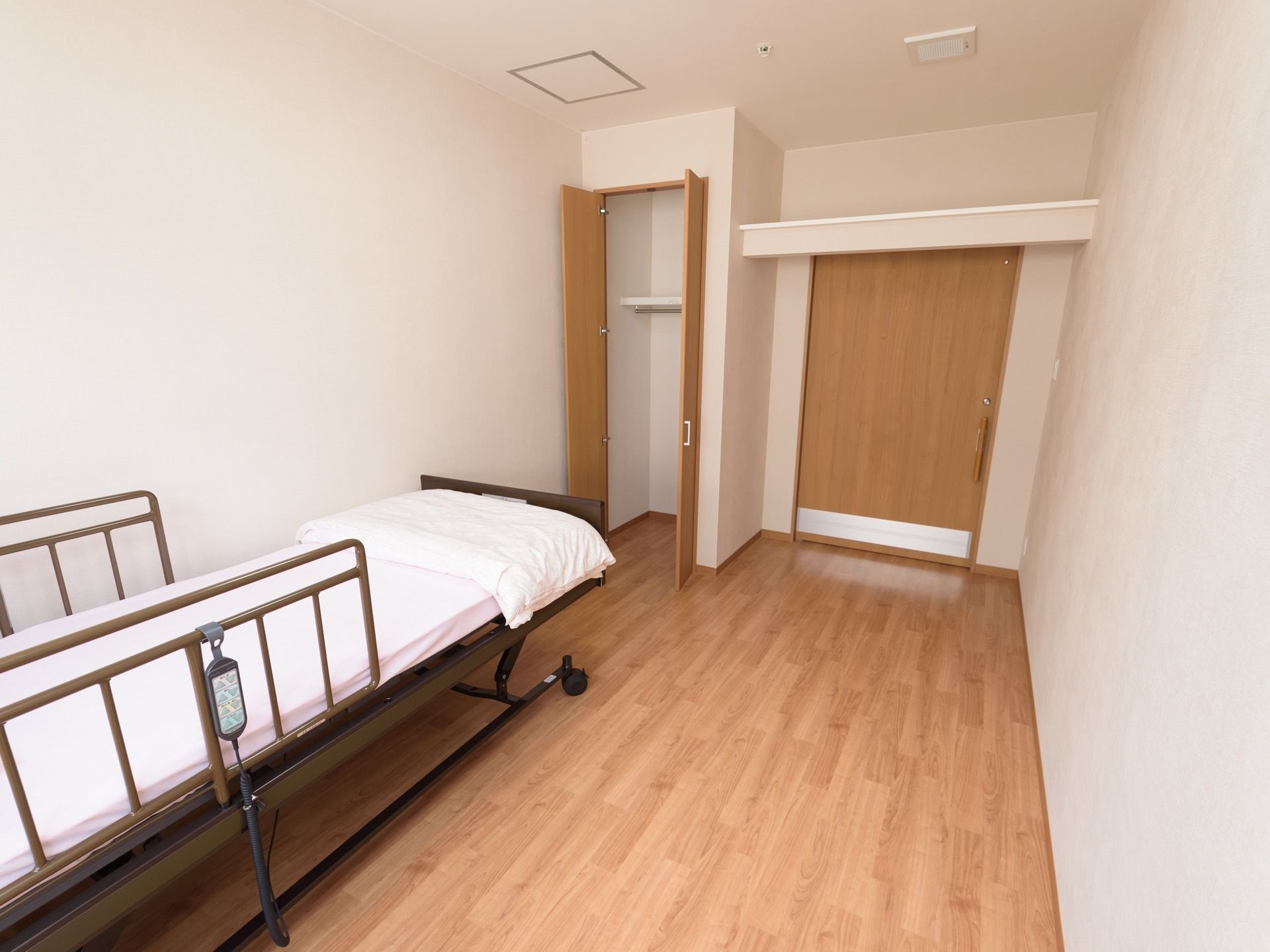 居室はシンプルで清潔感のある造りになっている。ベッドをドアと反対側に寄せて配置し、通路を広く設けている。