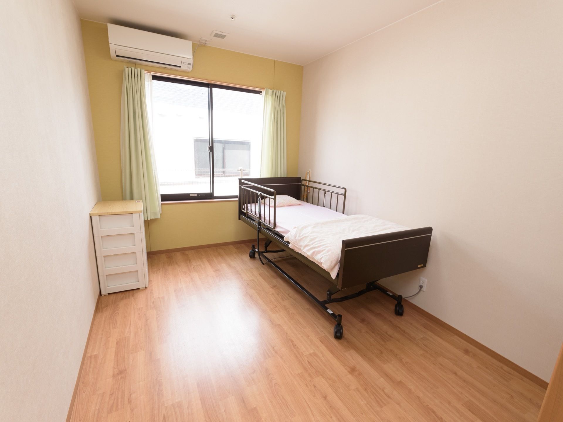 居室は窓際の一辺の壁を明るい黄色に変えて、アクセントにしている。部屋全体が引き締まった印象になり、おしゃれな雰囲気。