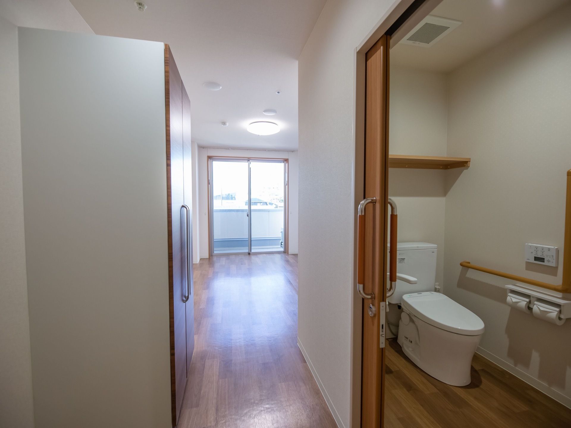 トイレは開閉が容易なスライド式の扉になっている。反対側の壁には両開きのクローゼットが設置されている。