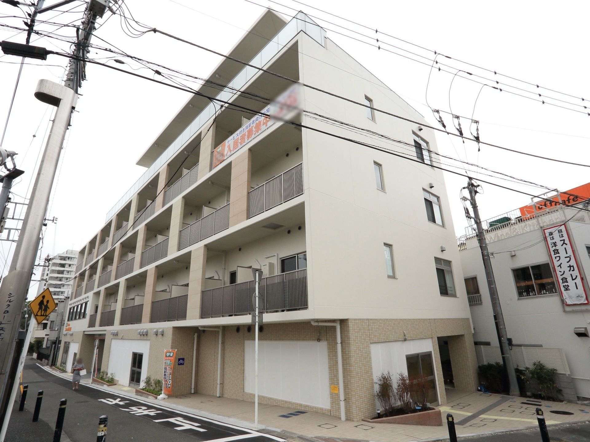 白を基調とした、マンション風の施設である。各居室にベランダが設置されている。目の前には道路が通っている。
