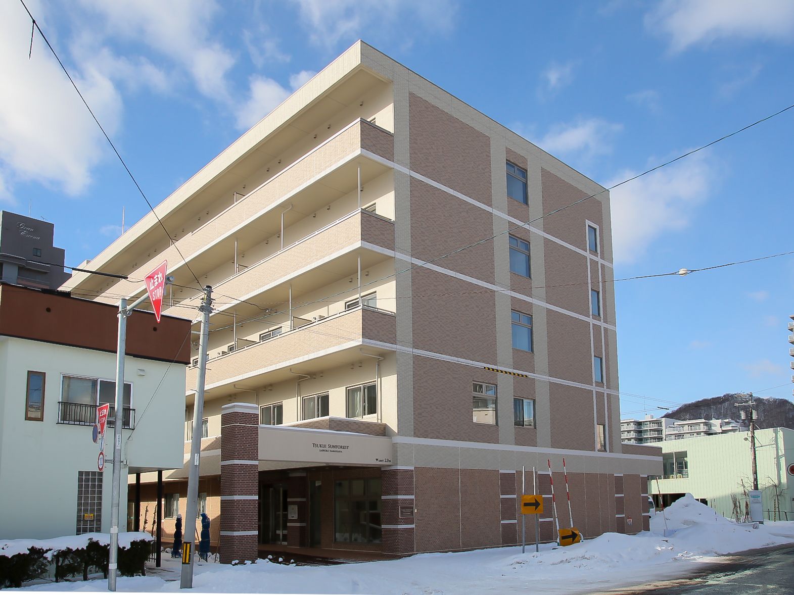 5階建ての建物はブラウンを基調としたどっしりとした造り。各フロアにベランダも付き、敷地内には緑も多い。
