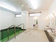 浴室はタイル張りになっており、窓が設けられている。浴槽の周囲には手すりが設置され、鏡とシャワー設備がある。