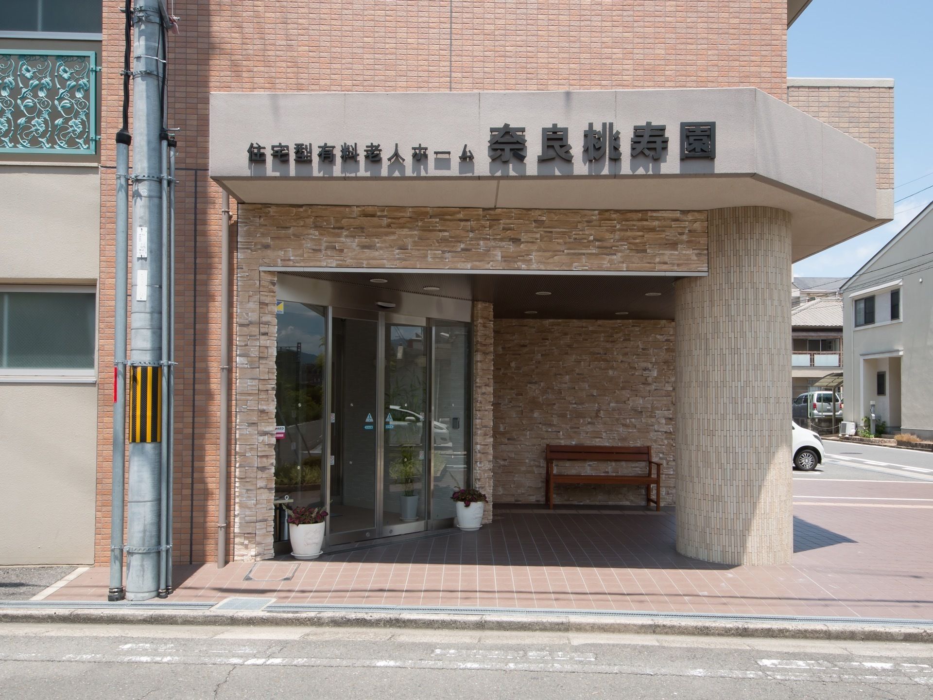 大きな文字で施設名の書かれた、自動開閉式のドアの玄関