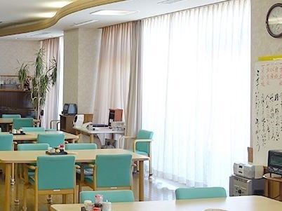 室内に並べられたテーブルには、調味料などがのせられている。窓にはカーテンがかけられ、壁際の棚にオーブントースターが置かれている。
