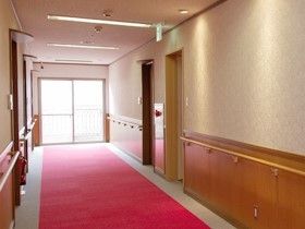 廊下はバリアフリーになっており、壁には隙間なく手すりが付いている。ドアとドアの間には、火災報知器や消火器が設置されている。