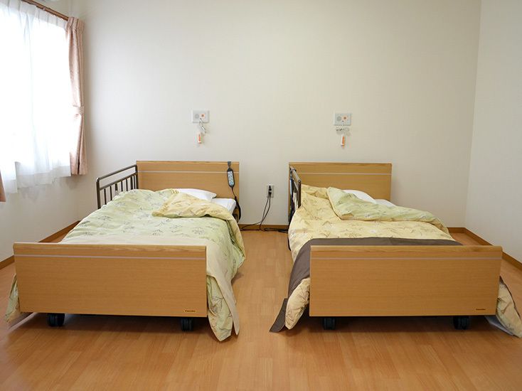 館内には、ご夫婦でもお過ごしいただける２人用の居室も設けている。大きな窓があり明るい空間に、介護用ベッドを並べて配置している。