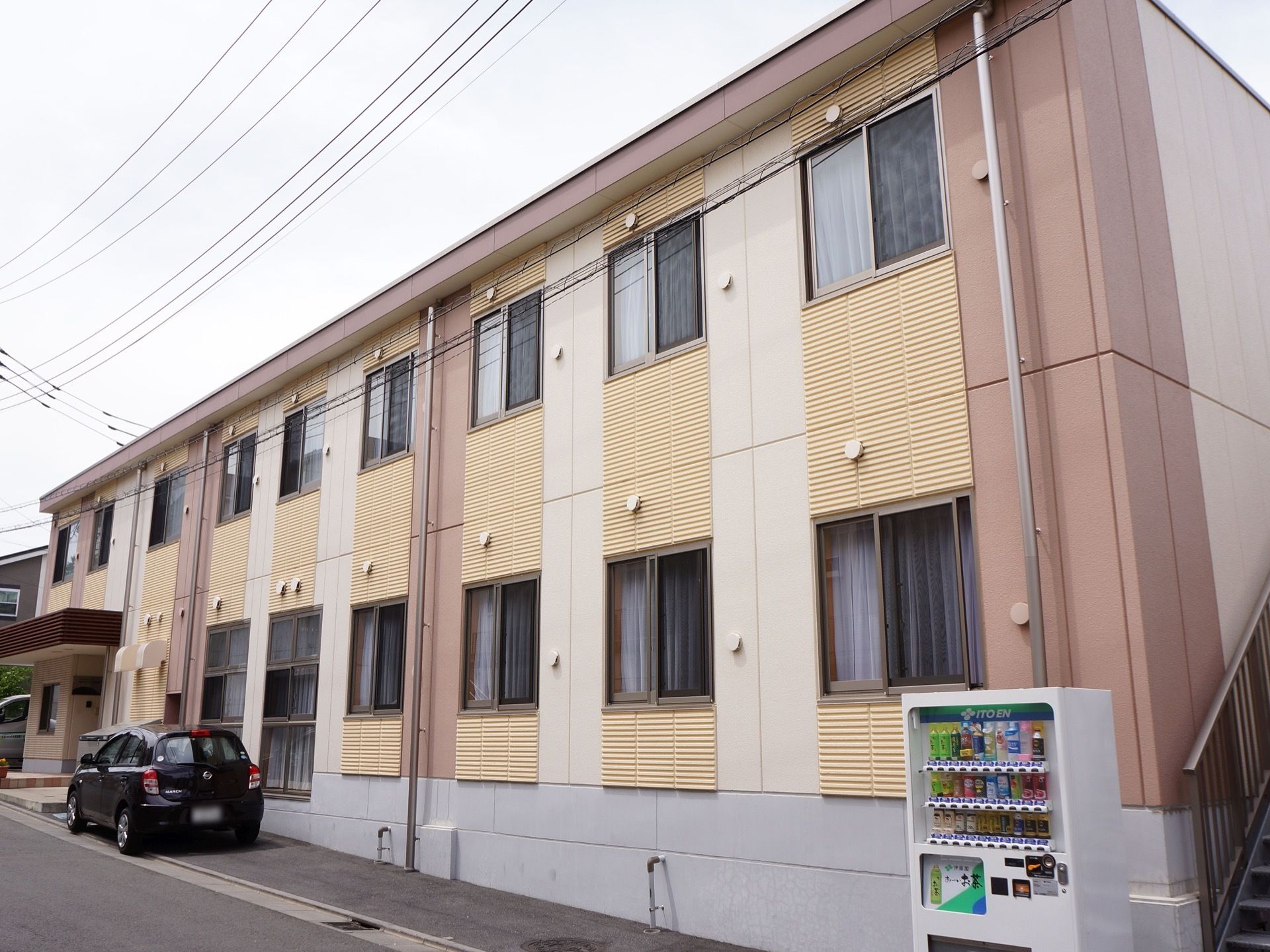 やさしい色合いの外観で、心が落ち着く雰囲気がただよう。建物の端に自動販売機が設置され、飲み物を買うのに便利である。
