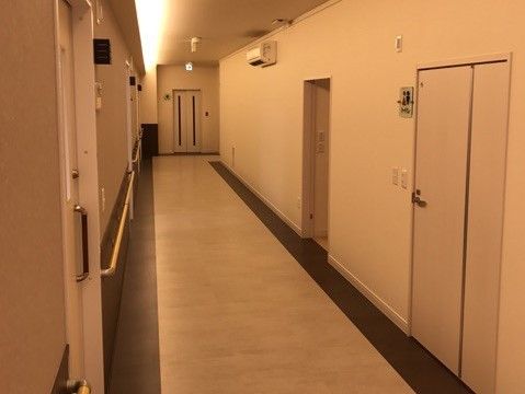 ゆったりとした空間の廊下である。掃除は行き届いており、天井下の壁にはエアコンを設置し、快適に移動が行える環境を整えている。